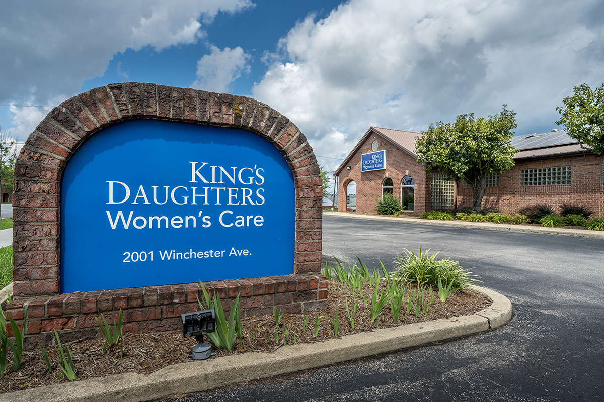 Exterior of UKKD Women's Care building with sign in foreground