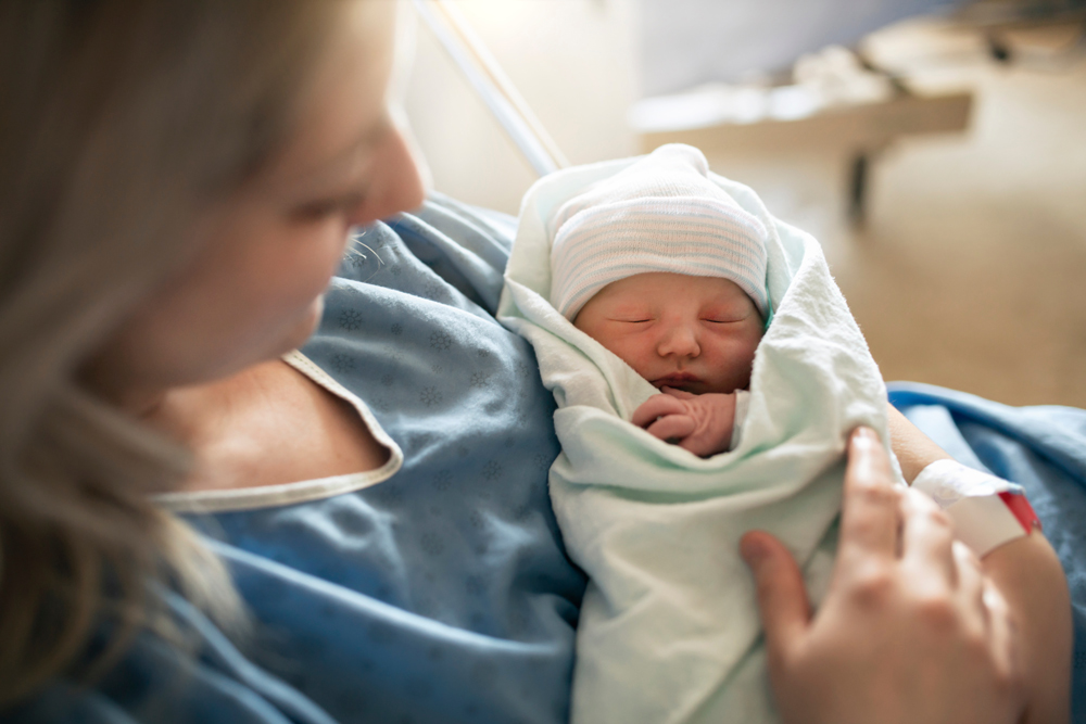 Mother holds newborn baby in the hospital. 