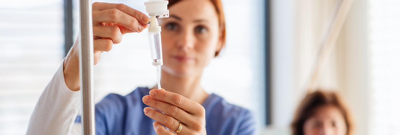 Healthcare provider adjusts an IV treatment for a patient. 