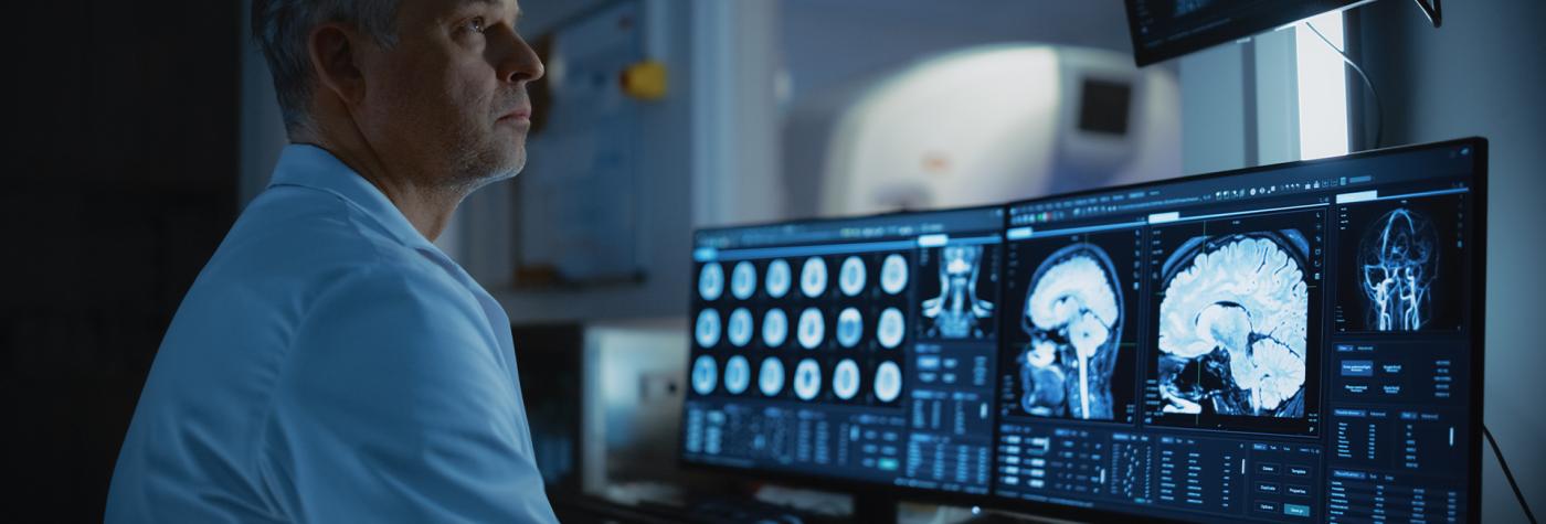 Neurology provider monitors brain scan results on a computer screen