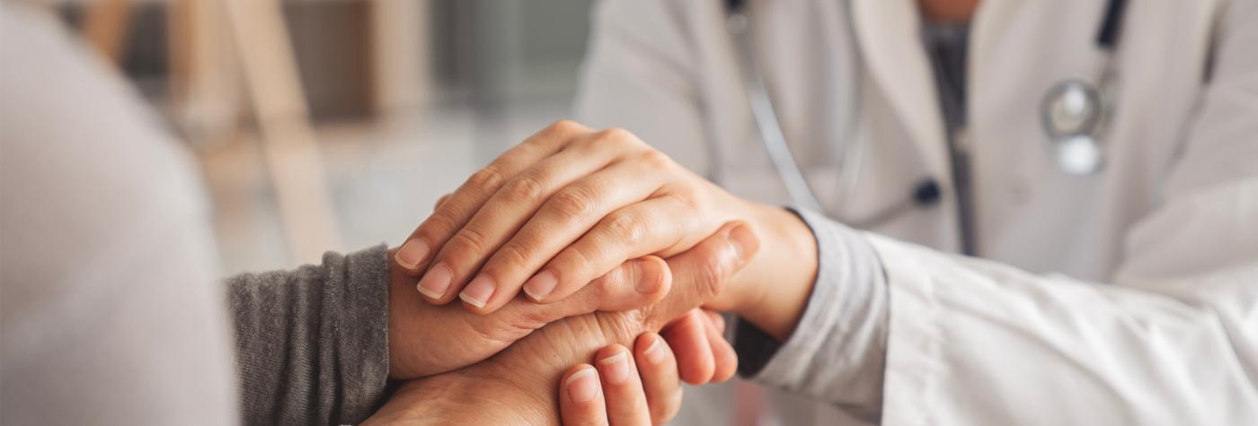 Healthcare provider holds hands with patient