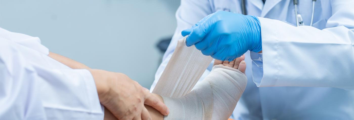 Medical provider wraps a patient's foot and ankle in bandage 