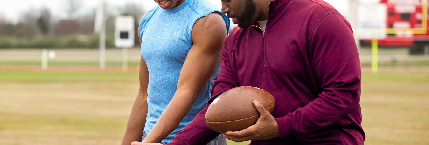 Athletic trainer helping football player on field