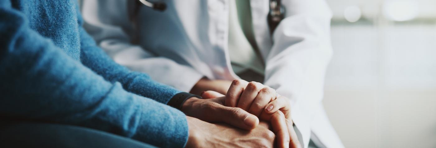 Healthcare provider holds hands with patient