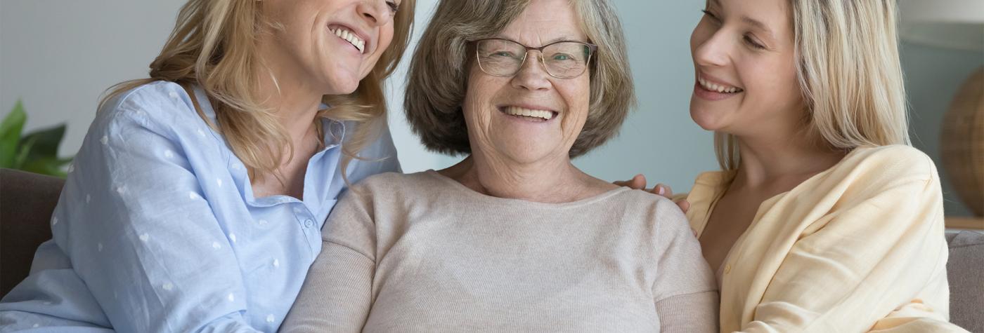 Grandmother, mother and daughter laugh together. 