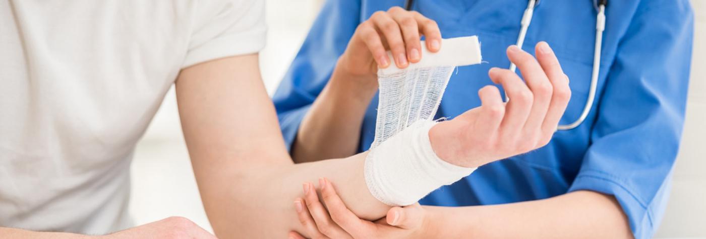Healthcare provider wraps a patient's wrist in gauze