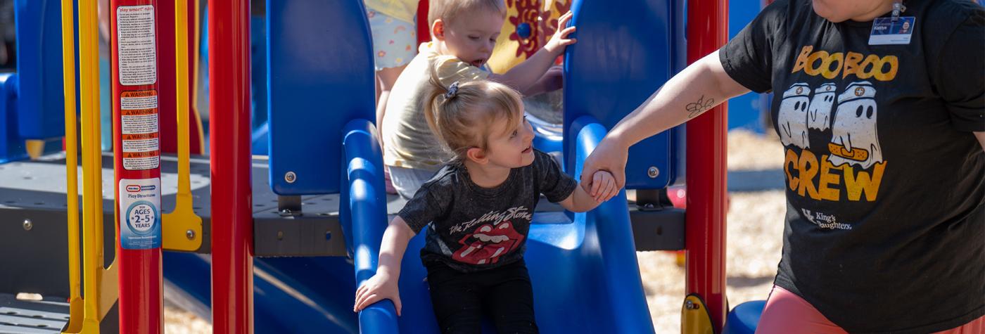 Children going down the slide at Child Development Center