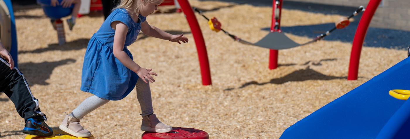 Child playing on playground equipment at Child Development Center