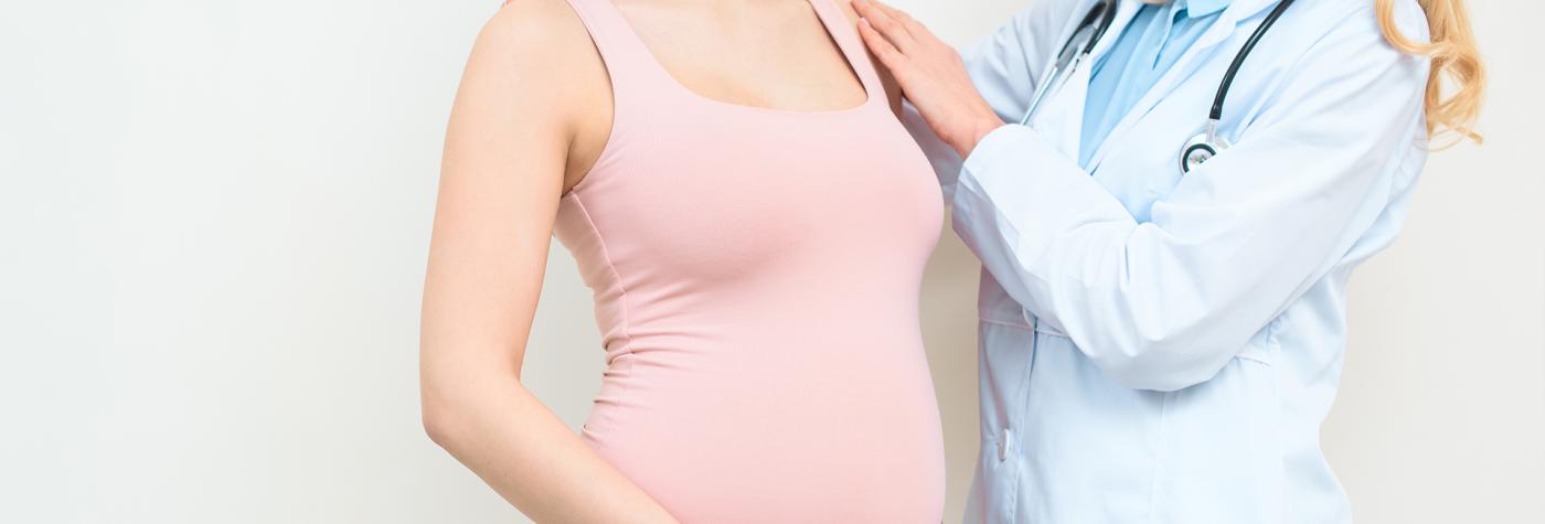 Healthcare provider standing beside pregnant patient. 